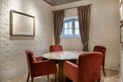 a dining room with a marble table and chairs at Santo Mauro, a Luxury Collection Hotel, Madrid in Madrid