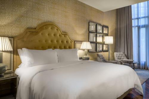 a bedroom with a large white bed and a large window at Santo Mauro, a Luxury Collection Hotel, Madrid in Madrid