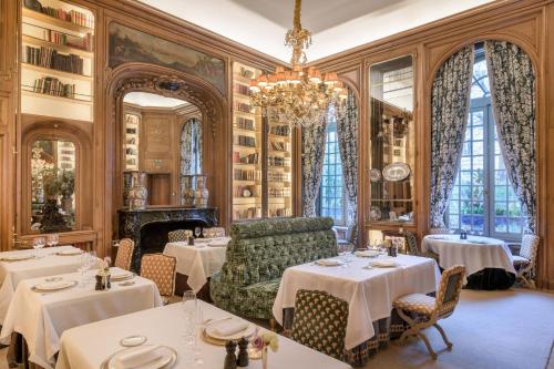 a dining room with tables and a chandelier at Santo Mauro, a Luxury Collection Hotel, Madrid in Madrid