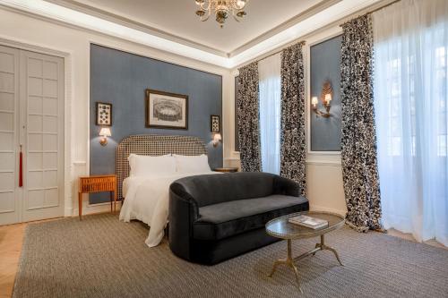 a bedroom with a bed and a chair and a couch at Santo Mauro, a Luxury Collection Hotel, Madrid in Madrid