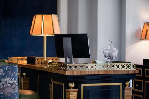 a living room with a desk with a television on it at Santo Mauro, a Luxury Collection Hotel, Madrid in Madrid
