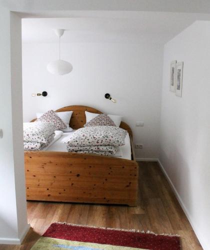 a bedroom with a wooden bed with pillows on it at Appartement Gensungen in Felsberg