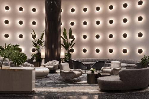 a lobby with couches chairs and tables in a building at The Ritz-Carlton South Beach in Miami Beach