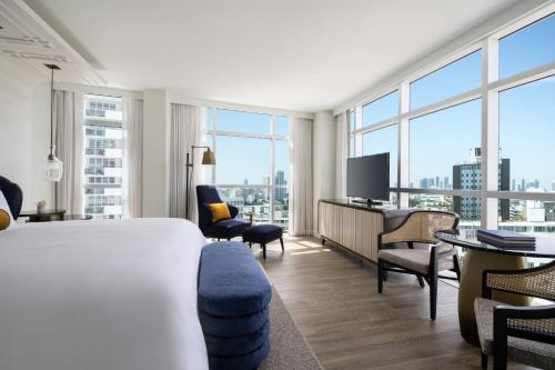 マイアミビーチにあるThe Ritz-Carlton, South Beachのベッド、デスク、テレビが備わるホテルルームです。
