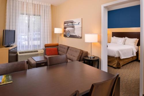 TownePlace Suites Wilmington Wrightsville Beach في ويلمنجتون: غرفة فندق بسرير وطاولة في غرفة