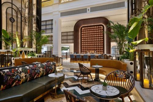 a lobby with a couch and tables and chairs at The Westin Dubai Mina Seyahi Beach Resort and Waterpark in Dubai