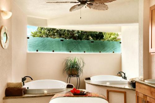 two tubs in a bathroom with a window at Sheraton Maui Resort & Spa in Lahaina