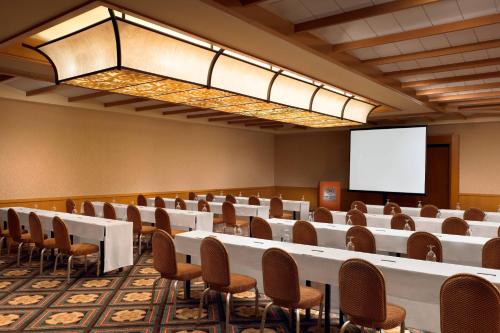 a conference room with tables and chairs and a screen at Sheraton Maui Resort & Spa in Lahaina