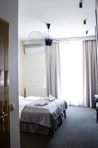 a bedroom with a bed and a large window at Arboretum Hotel in Wolbórz