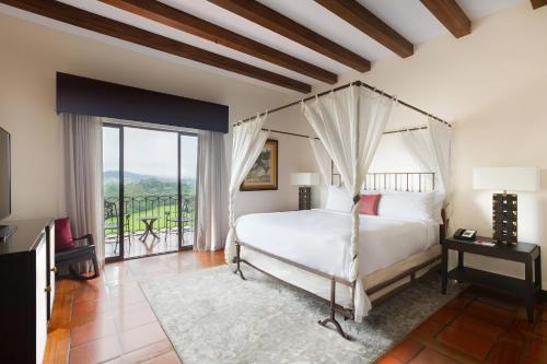 sypialnia z łóżkiem i dużym oknem w obiekcie Costa Rica Marriott Hotel Hacienda Belen w San José