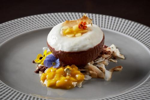 a white plate with a chocolate cupcake with white frosting at The Ritz-Carlton, Tysons Corner in Tysons Corner