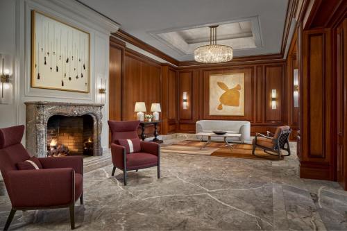 a living room with a fireplace and a couch and chairs at The Ritz-Carlton, Tysons Corner in Tysons Corner