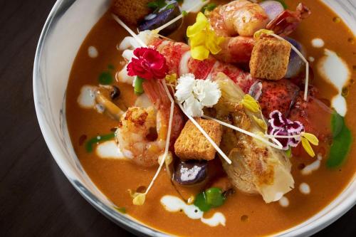 a bowl of soup with shrimp and other foods at The Ritz-Carlton, Tysons Corner in Tysons Corner