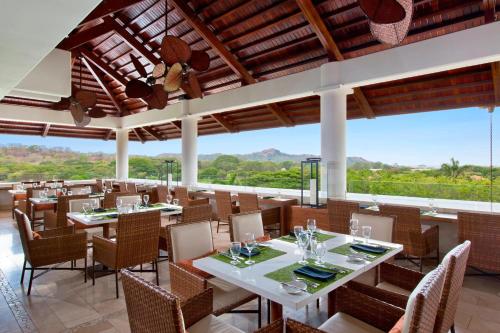 a restaurant with tables and chairs with a view at The Westin Reserva Conchal, an All-Inclusive Golf Resort & Spa in Playa Conchal