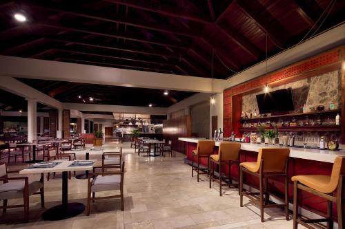 a restaurant with tables and chairs and a bar at The Westin Reserva Conchal, an All-Inclusive Golf Resort & Spa in Playa Conchal