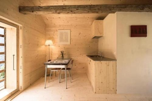 uma pequena cozinha com uma mesa num pequeno quarto em Mayen à Henri em Haudères