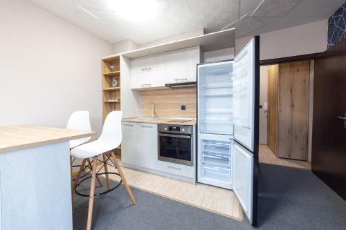 Luxury Studio Apartment - Varna Residens في مدينة فارنا: مطبخ مع ثلاجة وطاولة وكراسي