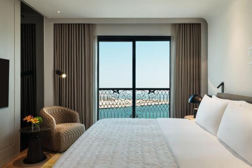 a hotel room with a bed and a balcony at Le Royal Méridien Place Vendôme Lusail in Doha