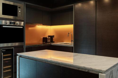 a kitchen with black cabinets and a counter top at Le Royal Méridien Place Vendôme Lusail in Doha