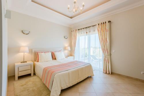 ein Schlafzimmer mit einem Bett und einem großen Fenster in der Unterkunft Boavista Golf and Spa Resort - 101 in Lagos