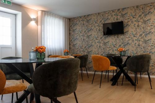 d'une salle à manger avec 2 tables, 2 chaises et une télévision. dans l'établissement Quinta das Areias - Solar da Pena, à Braga