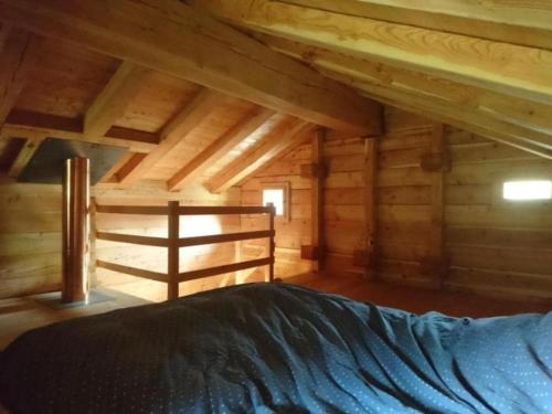 a bedroom with a bed in a wooden cabin at Raccard de Seppec in La Forclaz