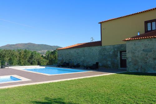 une maison avec une piscine à côté d'une cour dans l'établissement Quinta das Areias - Solar da Pena, à Braga