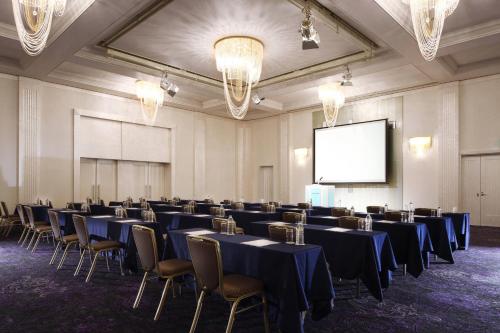 a conference room with tables and chairs and a screen at The Westin Osaka in Osaka