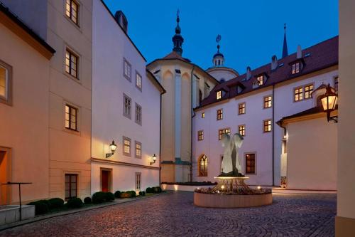 un bâtiment avec une statue au milieu d'une cour dans l'établissement Augustine, a Luxury Collection Hotel, Prague, à Prague