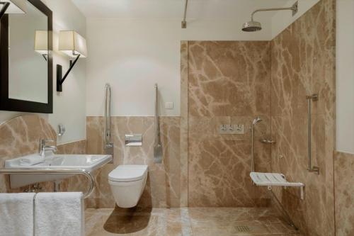 a bathroom with a toilet and a sink and a shower at Augustine, a Luxury Collection Hotel, Prague in Prague