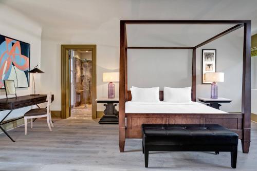 a bedroom with a large bed and a desk at Augustine, a Luxury Collection Hotel, Prague in Prague
