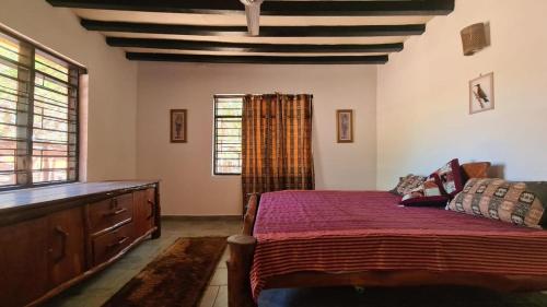 a bedroom with a bed and a dresser and window at Charming 2-Bed Cottage in Bodo a fishing village in Funzi