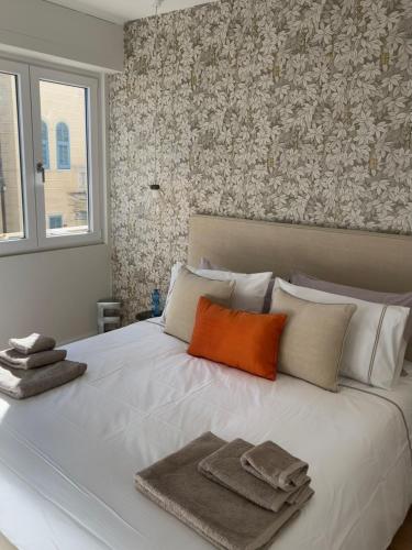 Una gran cama blanca con toallas encima. en Asso di Picche, Luxury suite, en San Remo
