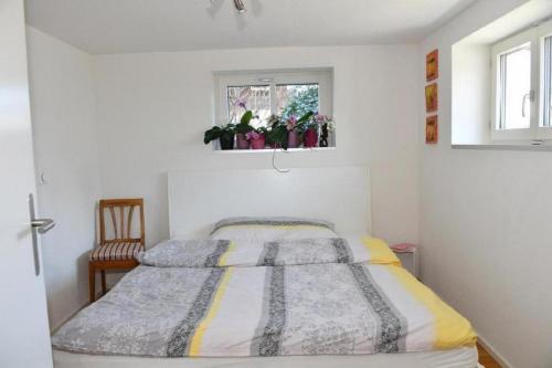 1 dormitorio con cama, ventana y silla en Seeblick - a78060 en Stalden