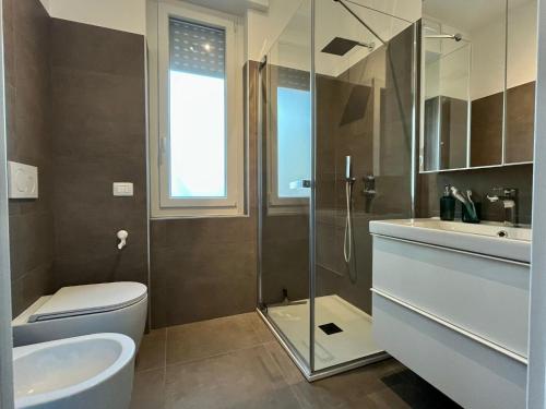 een badkamer met een toilet, een wastafel en een douche bij Cozy Apartment San Siro in Milaan