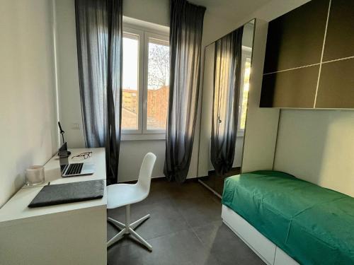 een slaapkamer met een bed en een bureau met een laptop bij Cozy Apartment San Siro in Milaan