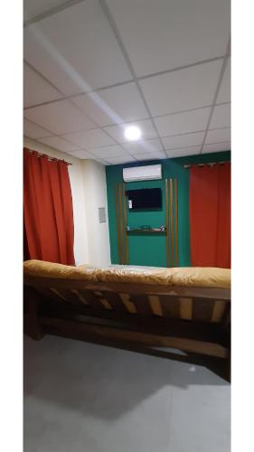 Una cama en una habitación con rojo y verde en Departamento calle San Martín San Rafael Mendoza en San Rafael