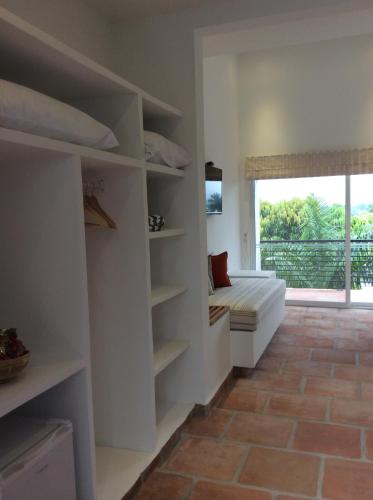 a living room with white shelves and a window at La Masia Hotel Boutique in Anapoima