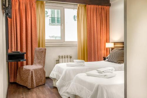 een hotelkamer met 2 bedden en een stoel bij Up Retiro in Buenos Aires