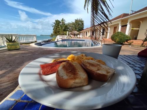 a plate of food on a table near a pool at Hotel Casa Canada in Big Corn Island