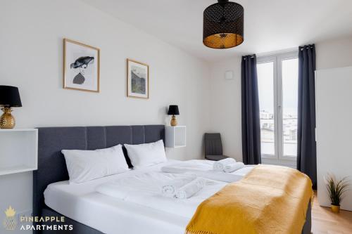 a bedroom with a large white bed with towels on it at Pineapple Apartments Dresden Altstadt V - 112 qm - 1x free parking in Dresden