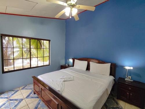 Hotel Casa Canada في جزيرة بيغ كورن: غرفة نوم زرقاء مع سرير مع مروحة سقف
