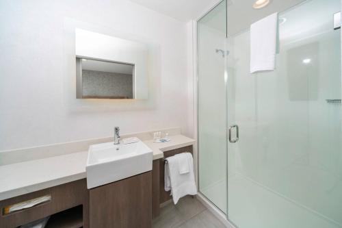 uma casa de banho branca com um lavatório e um chuveiro em SpringHill Suites Island Park Yellowstone em Island Park