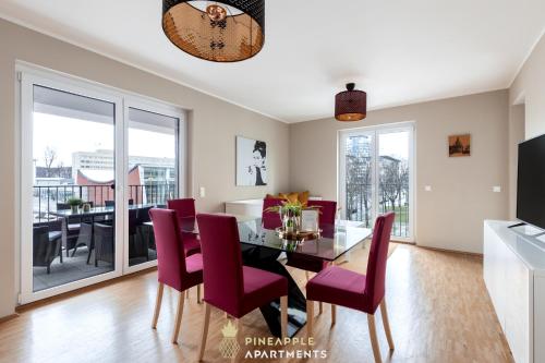 una sala da pranzo con tavolo in vetro e sedie viola di Pineapple Apartments Dresden Zwinger III - 86 qm - 1x free parking a Dresda