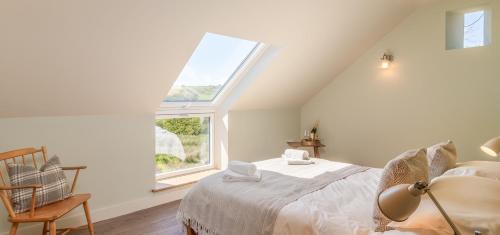 a bedroom with a bed and a large window at Green End Farm Cottages - The Cow Barn in Goathland