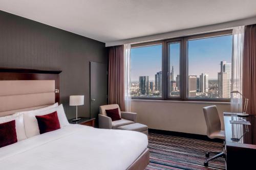 a hotel room with a bed and a large window at Frankfurt Marriott Hotel in Frankfurt