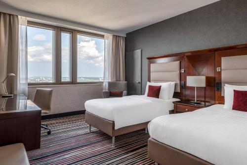 a hotel room with two beds and a large window at Frankfurt Marriott Hotel in Frankfurt/Main