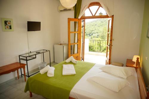 Un dormitorio con una cama verde y blanca y una ventana en Irida Rooms 'n' Pool - Cozy Summer Escape en Paralia Panteleimonos