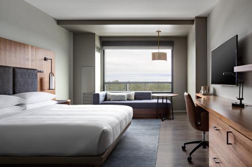 1 dormitorio con cama, escritorio y sofá en Houston CityPlace Marriott at Springwoods Village en The Woodlands