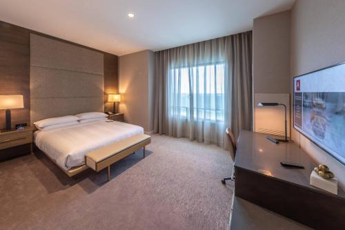 a hotel room with a bed and a flat screen tv at Houston CityPlace Marriott at Springwoods Village in The Woodlands